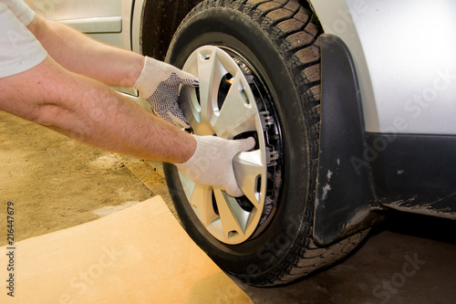 A mechanic removing the hubcap from a car wheel. Tire fitting. Tire service. photo