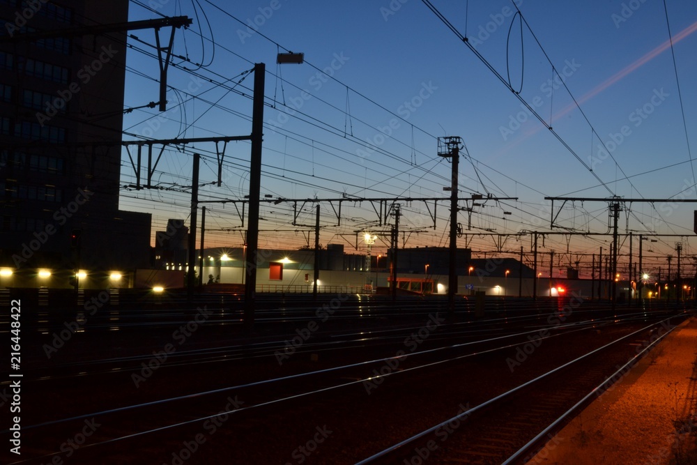 Nighttime photograph of railway tracks, taken shortly after sundown in Leuven, Belgium.