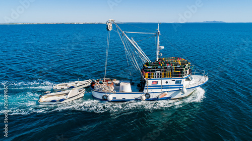 Fishing boat pulling two other smaller fishing boats © Nikola