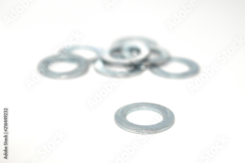 A few big industrial galvanized steel washers on white background