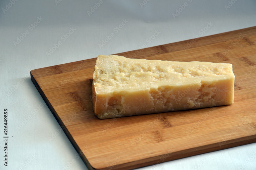 grana padano cheese on wooden chopping board