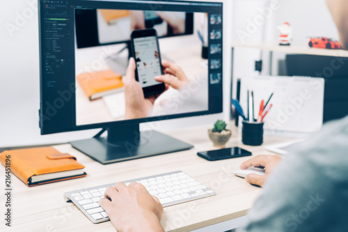 Young man working editing photo styles on pc computer screen at home, photography business