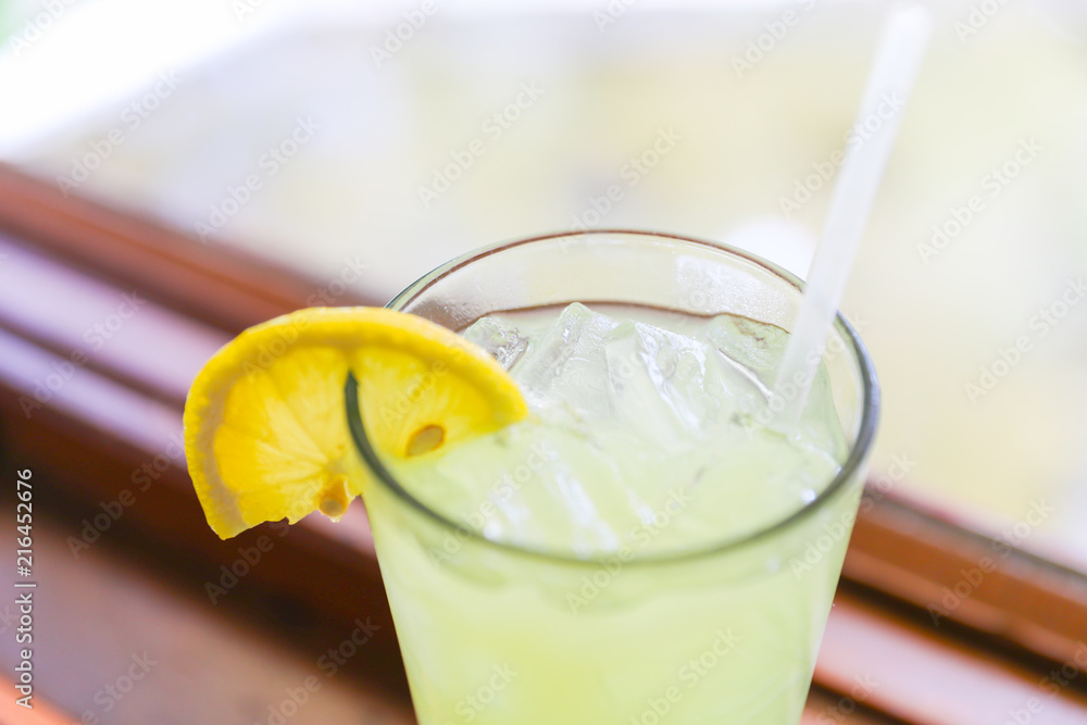 Drink for hot summer days. Fresh lime and lemon lemonade in a glass on a wooden desk Drink for hot summer days. Fresh lime and lemon lemonade in a glass on a wooden desk