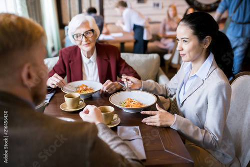 Business partners sitting at the table and communicating during business lunch