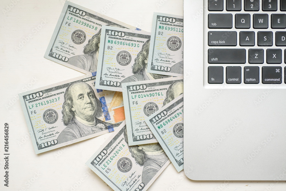 Dollar bills appearing from above the mining laptop Dollar bills appearing from above the mining laptop