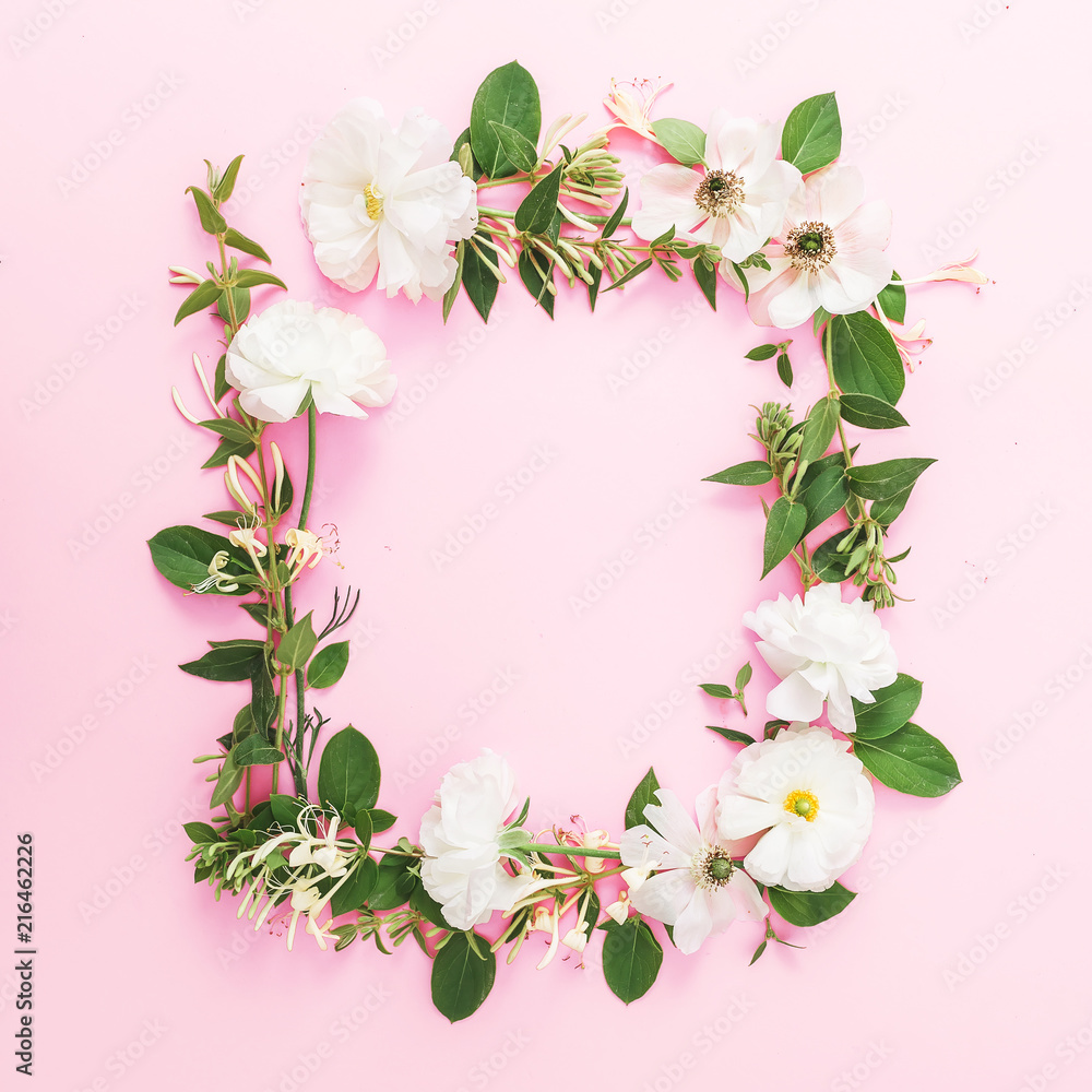 Frame of white flowers and leaves on pink pastel background. Flat lay, top view. Floral pattern