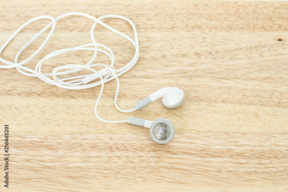 earbuds or earphones on wooden background earbuds or earphones on wooden background