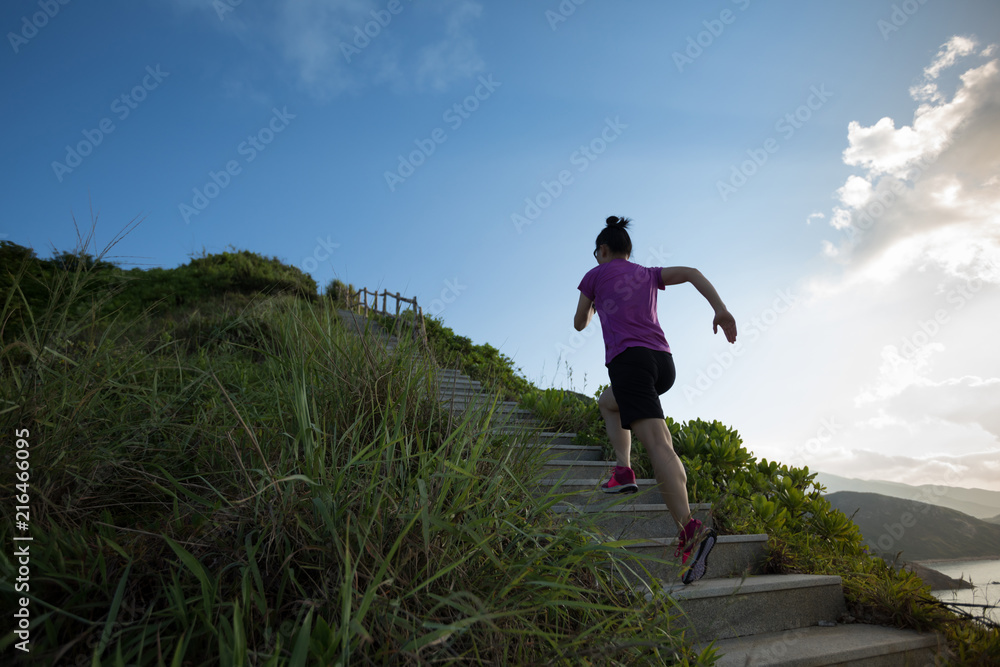 Woman running up on seaside mountain stairs Woman running up on seaside mountain stairs