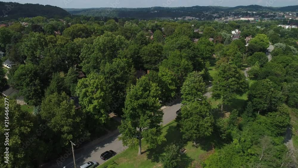 A rising aerial establishing shot of the residential district of a small town in western Pennsylvania on a summer day. Pittsburgh suburbs. A rising aerial establishing shot of the residential district of a small town in western Pennsylvania on a summer day. Pittsburgh suburbs.