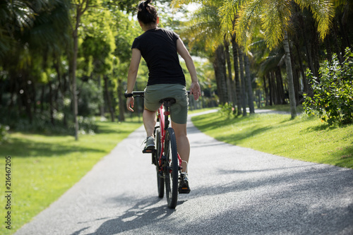 Woman riding mountain bike in tropical park