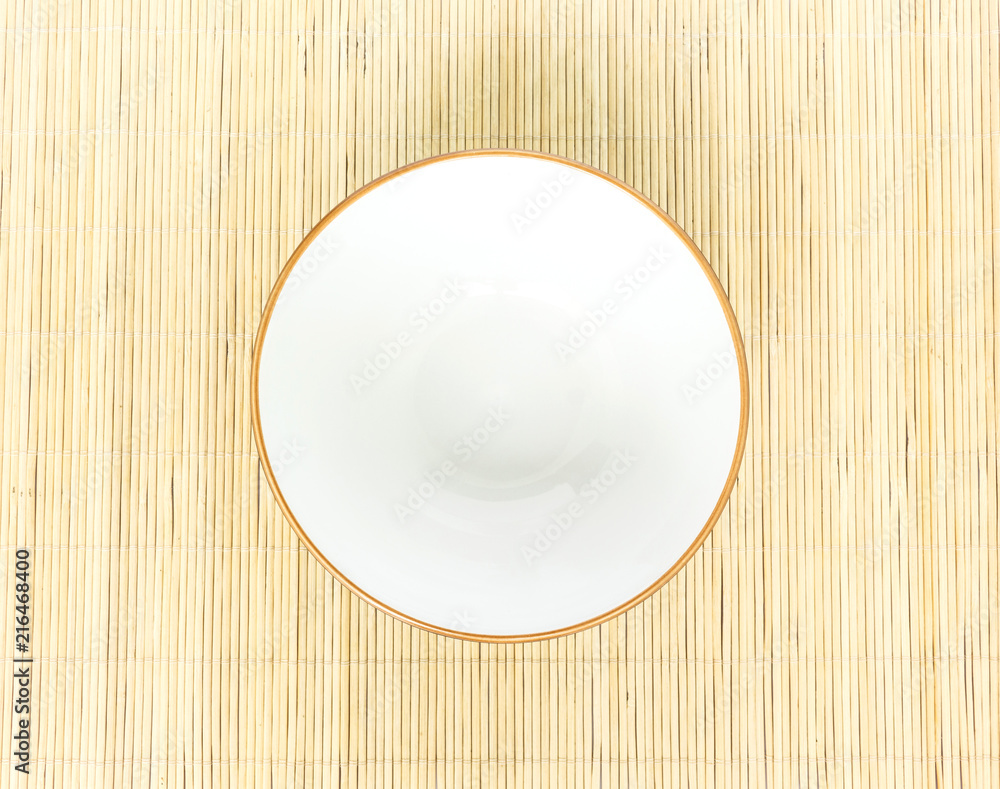 White bowl top view isolated on wooden mat background White bowl top view isolated on wooden mat background