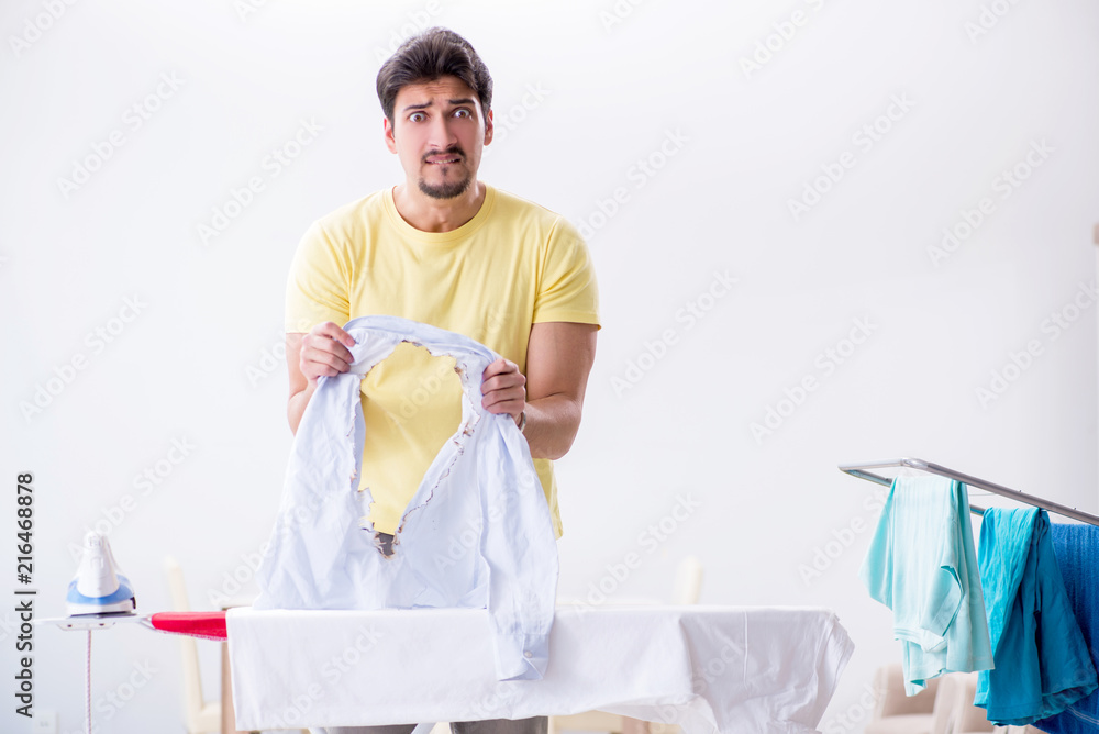 Handsome man husband doing clothing ironing at home Handsome man husband doing clothing ironing at home