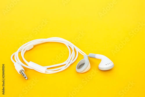 earbuds or earphones on yellow background