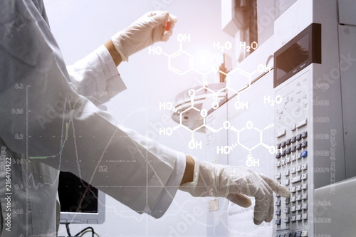 scientist holds an amber vial and press the control button of GC chromatography