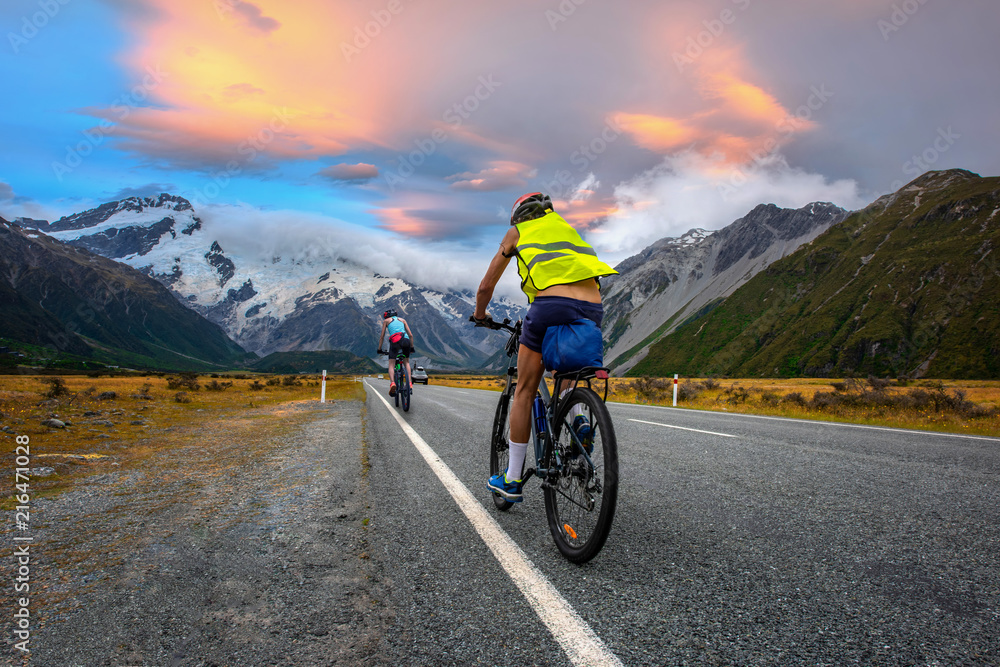 cyclist mountain bikes family enjoy riding on the road in countryside with beautiful mountain cook in New zealand in back ground
