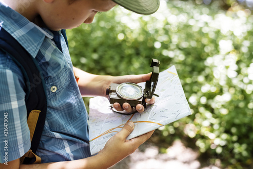 Boy following the directions of a compass photo