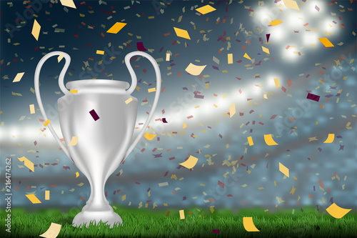 silver trophy cup on soccer stadium background with confetti