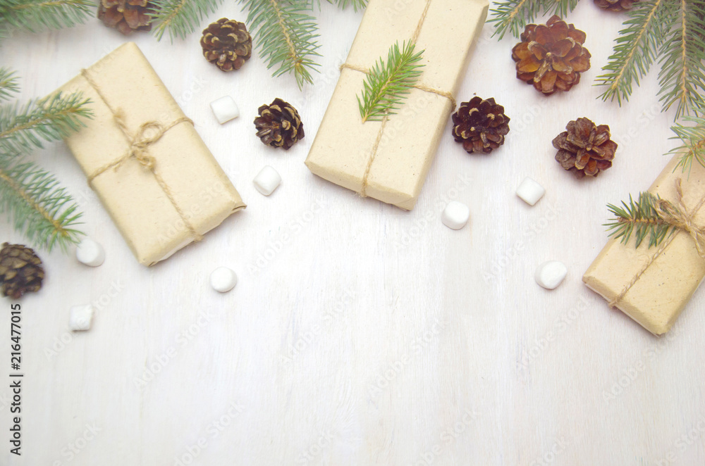 Christmas background tree branches cones and gifts on wooden white background Christmas background tree branches cones and gifts on wooden white background