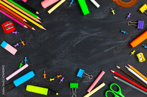 Back To School concept. School supplies on blackboard background, accessories for the schoolroom - pencils, notebooks, scissors, chalk, markers.