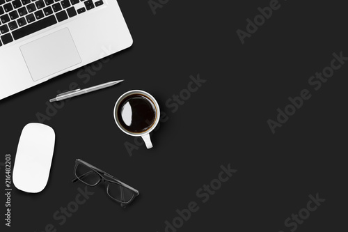 Modern black office desk table with laptop, cup of coffee and office supplies. Top view with copy space, flat lay.