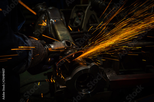 Industry worker cutting metal with grinder 