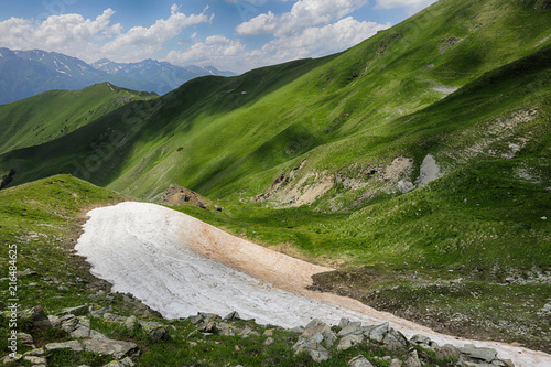 Picturesque mountain green valley of the river Zagedanka and snow in the Caucasus Mountains. Russia. photo