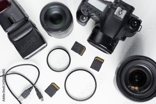 modern photo camera, lenses and equipment over white table