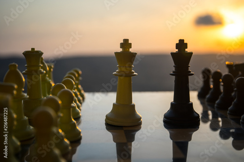 chess board game concept of business ideas and competition and strategy ideas. Chess figures on a chessboard outdoor sunset background.