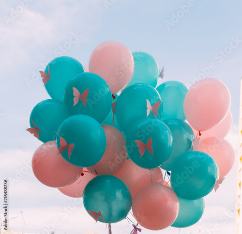 a bunch of beautiful pink and green balls, the color of the sea wave, with butterflies on them,against the backdrop of the sky