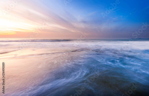 beautiful waves trails during sunset. natural coastal rocks on the ground with colourful blue hour sky.