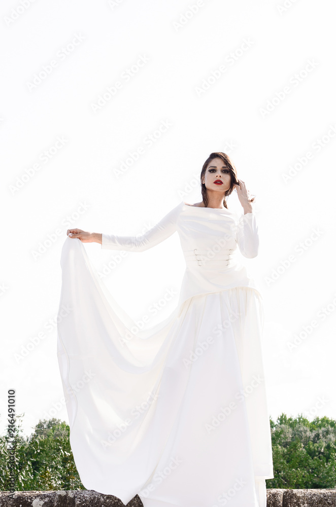 Girl standing outside in long white dress Girl standing outside in long white dress