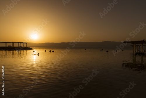 People bathing in the dead sea at sunrise