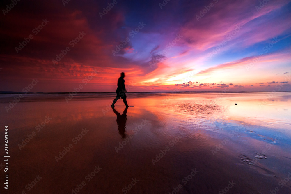 Sunrise with beautiful reflection.  silhouette  of unknown people appear on the image. 