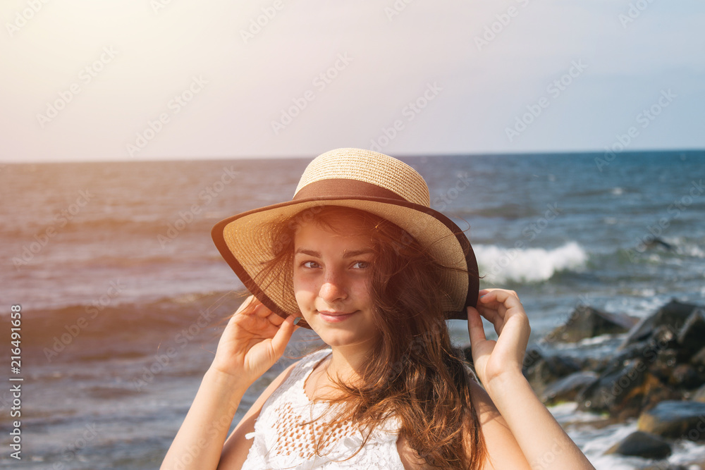 Girl in a hat on the background of the sea