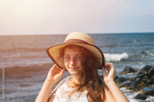 Girl in a hat on the background of the sea