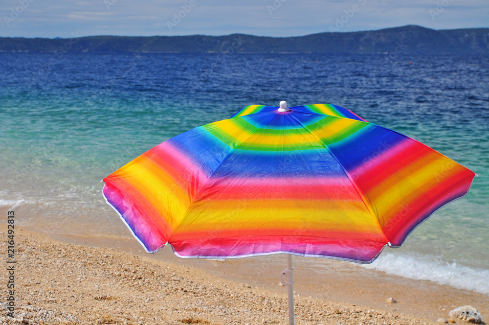 Colorful parasol on beach by sea holidays