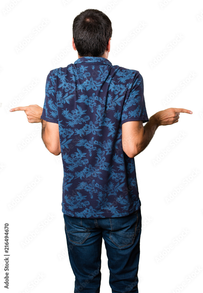 Brunette man pointing to the laterals having doubts on white background Brunette man pointing to the laterals having doubts on white background