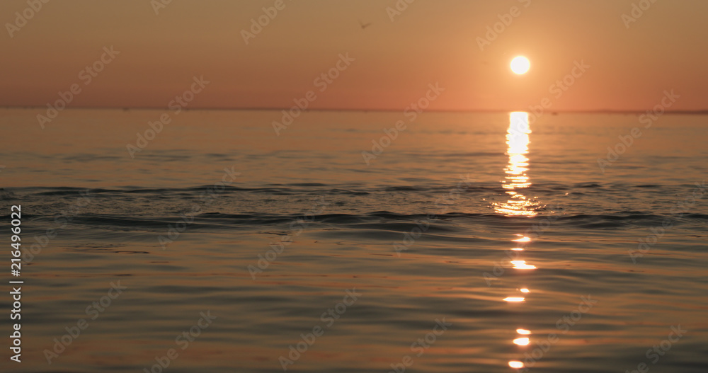 small waves on a beach at sunset