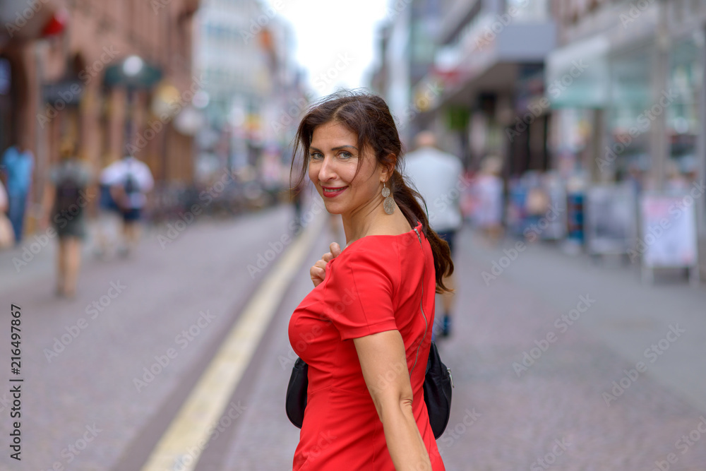Adult woman looking over shoulder at camera Adult woman looking over shoulder at camera