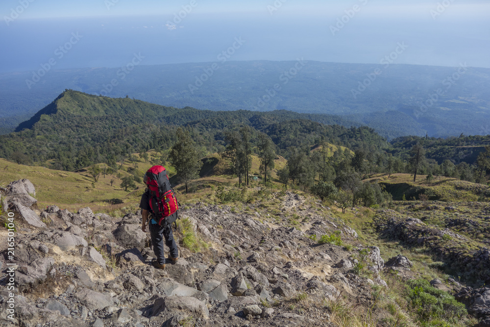 Unidentified mountain guide with trekking pole looks on the way to Rinjani Mountain in Lombok, Indonesia.
