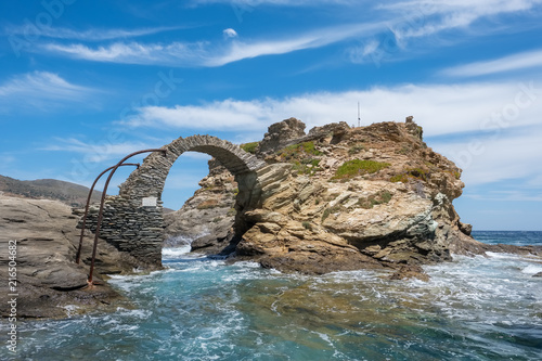 Old arched stone bridge in the beautiful town of Chora on Andros island  Cyclades  Greece