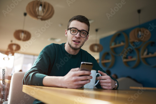 Portrait of concentrated american owner of IT corporation texting messages through online chat communicated with managers responsible for updating site content via smartphone connected to wifi photo