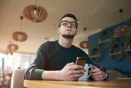 Portrait of concentrated american owner of IT corporation texting messages through online chat communicated with managers responsible for updating site content via smartphone connected to wifi photo