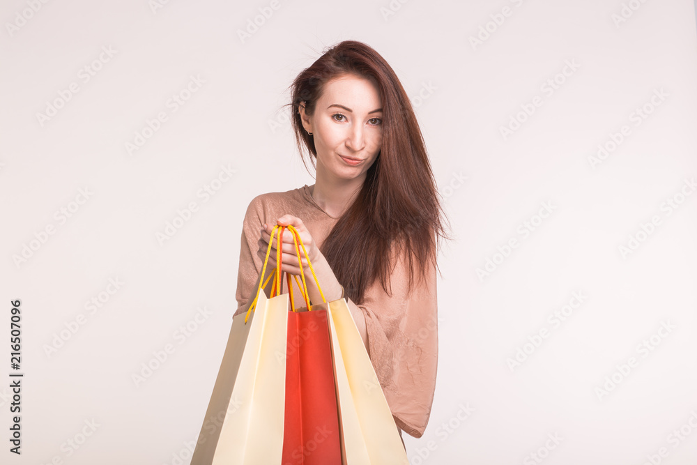 People, sale and consumerism concept - young asian woman over white background holding shopping bags People, sale and consumerism concept - young asian woman over white background holding shopping bags