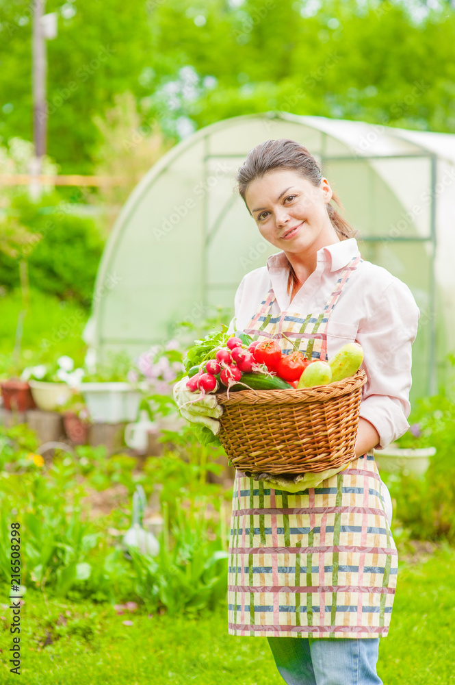 Happy woman with fresh vegetables in the basket in her hands Happy woman with fresh vegetables in the basket in her hands