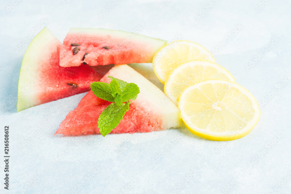 Watermelon. lemon and mint on blue background, ingredients for nonalcoholic mijito or smoothie Watermelon. lemon and mint on blue background, ingredients for nonalcoholic mijito or smoothie