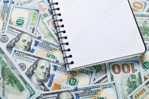Notebook for notes lying on money background from one hundred dollars