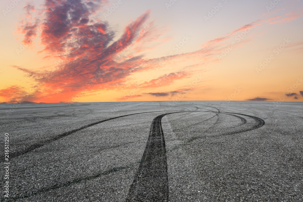 Asphalt square car tire brakes and beautiful colorful sky clouds at sunrise