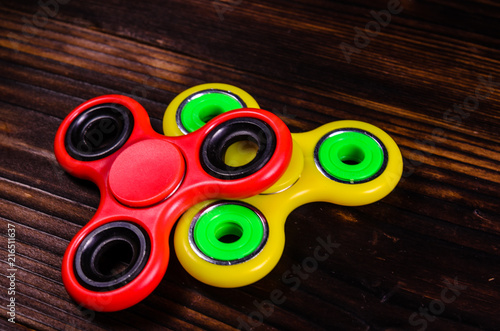 Two fidget spinners on wooden desk