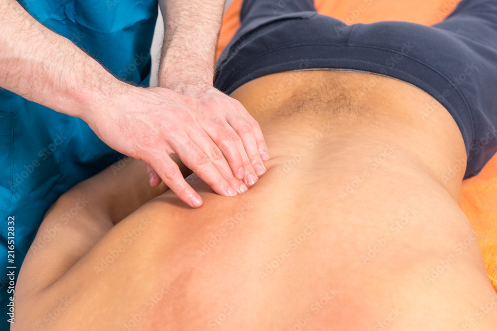 Masseur doing a back massage on a client Masseur doing a back massage on a client